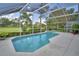 Screened-in swimming pool with lush green landscaping and nearby trees at 2350 Paulette Dr, Haines City, FL 33844