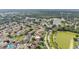 Scenic aerial view of a neighborhood with homes, mature trees, and a tranquil pond, showcasing a serene setting at 2602 Whitewood Rd, Mulberry, FL 33860