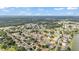 Expansive aerial view showcasing the neighborhood with tree-lined streets and a picturesque community pond at 2602 Whitewood Rd, Mulberry, FL 33860
