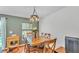 Dining area features a wooden table, chandelier lighting, and a view of the pool area at 2602 Whitewood Rd, Mulberry, FL 33860