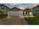 Charming home with a well-manicured lawn, features a two-car garage and inviting front entrance at 2602 Whitewood Rd, Mulberry, FL 33860