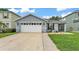 Charming single-story home with a two-car garage, green lawn, and landscaped front at 2602 Whitewood Rd, Mulberry, FL 33860