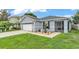 Light-grey single-story home featuring an attached two-car garage and a screened in porch at 2602 Whitewood Rd, Mulberry, FL 33860