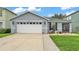 Charming single-story home with a two-car garage, green lawn, and landscaped front at 2602 Whitewood Rd, Mulberry, FL 33860