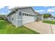 Side view of a light-grey house with an attached garage and a well-maintained lawn at 2602 Whitewood Rd, Mulberry, FL 33860