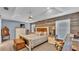Spacious main bedroom featuring a rustic wood accent wall, tray ceiling, and a ceiling fan at 2602 Whitewood Rd, Mulberry, FL 33860