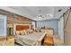 Spacious main bedroom featuring a rustic wood accent wall, tray ceiling, and a ceiling fan at 2602 Whitewood Rd, Mulberry, FL 33860