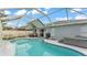 Relaxing backyard pool with screened-in enclosure, hot tub, and outdoor grill, perfect for entertaining at 2602 Whitewood Rd, Mulberry, FL 33860