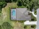 Aerial view of a private backyard pool and spa with a screen enclosure, lush landscaping, and the house at 2977 Sequoyah Dr, Haines City, FL 33844