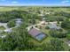 A verdant aerial view of a screened-in pool home and lush landscaping amidst a vibrant neighborhood at 2977 Sequoyah Dr, Haines City, FL 33844
