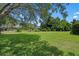 Expansive backyard with lush green grass and mature trees, perfect for outdoor activities and relaxation at 2977 Sequoyah Dr, Haines City, FL 33844