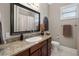 Bathroom featuring granite countertop vanity, large mirror, and decorative wall art at 2977 Sequoyah Dr, Haines City, FL 33844