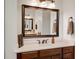 Bathroom vanity with dark wood cabinets, white countertops, and a large, framed mirror with decorative lighting at 2977 Sequoyah Dr, Haines City, FL 33844