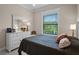 Bright bedroom featuring a white bed frame, ceiling fan, a dresser, and large window at 2977 Sequoyah Dr, Haines City, FL 33844