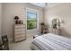Well-lit bedroom with woven dresser, mirror, and a bright window view of lush greenery at 2977 Sequoyah Dr, Haines City, FL 33844