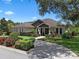 Well-maintained home features a stone facade, manicured landscaping and brick-paved driveway at 2977 Sequoyah Dr, Haines City, FL 33844