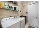 Laundry room featuring white washer and dryer, storage shelves, and convenient utility sink at 2977 Sequoyah Dr, Haines City, FL 33844