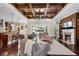 Open-concept living room showcasing a fireplace, access to the pool area, and a coffered wood ceiling at 2977 Sequoyah Dr, Haines City, FL 33844