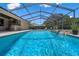 Beautiful screened-in pool with a waterfall feature and an outdoor bar area perfect for entertaining at 2977 Sequoyah Dr, Haines City, FL 33844