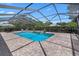 Screened-in pool with spa, lush landscaping, and an inviting outdoor relaxation area at 2977 Sequoyah Dr, Haines City, FL 33844