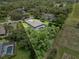 Aerial view of a house with a screened lanai and large backyard surrounded by lush trees and landscaping at 2988 Sequoyah Dr, Haines City, FL 33844