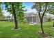 A lush green backyard featuring a screened-in porch, mature trees, and manicured landscaping at 2988 Sequoyah Dr, Haines City, FL 33844