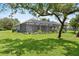 Expansive backyard showcasing a screened-in lanai and lush landscaping, perfect for outdoor living at 2988 Sequoyah Dr, Haines City, FL 33844