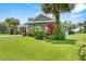 Landscaped front yard, showcasing the home's exterior and a healthy green lawn and mature trees at 2988 Sequoyah Dr, Haines City, FL 33844
