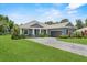 Beautiful gray single-story home with a well-manicured lawn and gray brick driveway at 2988 Sequoyah Dr, Haines City, FL 33844