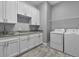 A well-equipped laundry room with granite countertops, white cabinetry, and modern washer and dryer at 2988 Sequoyah Dr, Haines City, FL 33844