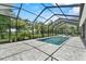 The screened-in pool offers a beautiful view of the green backyard, perfect for summer fun at 2988 Sequoyah Dr, Haines City, FL 33844