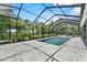 The screened-in pool offers a beautiful view of the green backyard, perfect for summer fun at 2988 Sequoyah Dr, Haines City, FL 33844