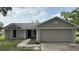 Charming single-story home featuring an attached two-car garage and a concrete driveway at 300 E Washington St, Minneola, FL 34715