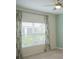 Cozy bedroom with neutral walls, ceiling fan and a large window with decorative curtains at 3023 Caneel, Winter Haven, FL 33884