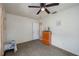 Neutral bedroom featuring a ceiling fan, wood dresser, and view into an adjoining room at 304 W Lake Ave, Auburndale, FL 33823
