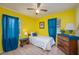 A bright bedroom with yellow walls and blue curtains framing the windows, inviting natural light at 304 W Lake Ave, Auburndale, FL 33823