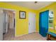 Hallway with bright yellow walls, tile flooring, and access to other rooms in the home at 304 W Lake Ave, Auburndale, FL 33823