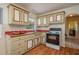 A traditional kitchen features wood cabinets, red countertops, and an archway to the adjacent hall at 304 W Lake Ave, Auburndale, FL 33823