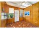 Cozy sunroom with wood paneled walls, mosaic tile floors, and bright windows at 304 W Lake Ave, Auburndale, FL 33823