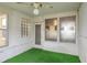 Sunroom with a glass brick window, decorative trim, and artificial green carpet at 304 W Lake Ave, Auburndale, FL 33823
