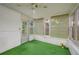 Bright sunroom with artificial green carpet, white walls, and a clear view of the backyard at 304 W Lake Ave, Auburndale, FL 33823