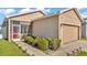 Close up of a tan home with a screened porch, a two car garage, and minimal landscaping at 3173 Whispering Trails Ave, Winter Haven, FL 33884