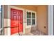 Close up view of a bright red front door with a large white window to the right at 3173 Whispering Trails Ave, Winter Haven, FL 33884
