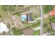 This aerial view showcases a home with solar panels and a backyard pool and spacious yard at 326 Sunset Rd, Frostproof, FL 33843