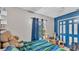 Cozy bedroom featuring blue and green bedding, a teddy bear, and blue paneled closet doors at 326 Sunset Rd, Frostproof, FL 33843