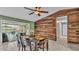 View of the dining room with ceiling fan, wood accent wall and slider to the backyard pool at 326 Sunset Rd, Frostproof, FL 33843