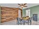 Dining room view featuring a wood accent wall, ceiling fan, and dining table with seating at 326 Sunset Rd, Frostproof, FL 33843