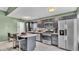 Galley kitchen featuring black cabinets, stainless steel appliances, and a cozy breakfast bar at 326 Sunset Rd, Frostproof, FL 33843