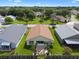 Aerial view of the backyard featuring a patio with palm trees, lush grass, and a wooden fence at 348 Lake Suzanne Dr, Lake Wales, FL 33859