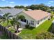 An aerial view of the backyard features a patio, palm trees, and lush landscaping at 348 Lake Suzanne Dr, Lake Wales, FL 33859